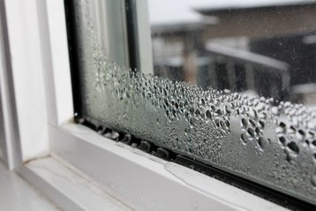 Kondenswasser an Fenstern in einem Neubau im Winter als normales Zeichen der Bautrocknung