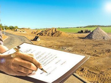 Baugrundstück mit Bauplan als Symbol für Grundstückssuche und Hausplanung